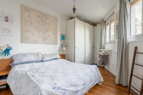 une chambre avec un lit et une grande fenêtre dans l'établissement Bel appartement cosy, emplacement idéal, à Paris