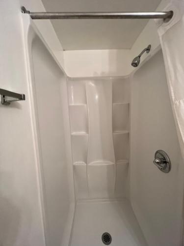 a white shower with shelves in a bathroom at Columbus Motor Inn in Seattle