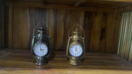 two clocks sitting next to each other in a room at homestayfidagerik in Gerik