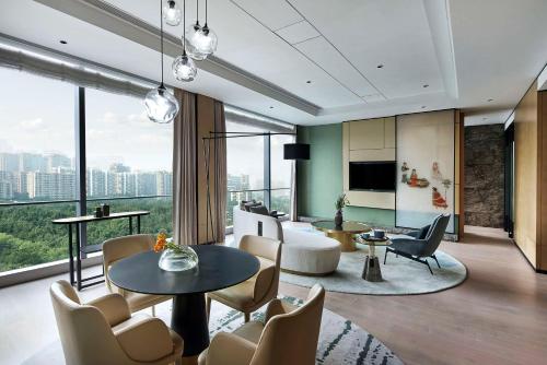 een woonkamer met een bank en een tafel en stoelen bij Kempinski Hotel Hangzhou in Hangzhou