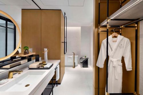 a bathroom with a white robe hanging on a rack at Kempinski Hotel Hangzhou in Hangzhou