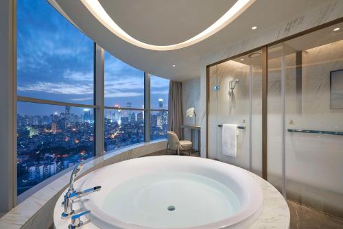 a bathroom with a large bath tub and a large window at Kempinski Hotel Nanjing in Nanjing