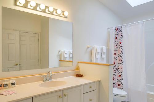a bathroom with a sink and a large mirror at Charming Galena Townhome Near Belvedere Mansion! in Galena