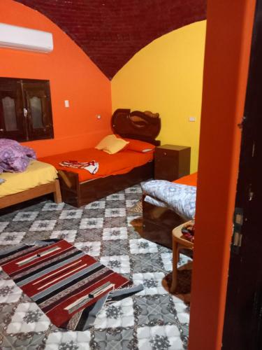 a room with two beds and a rug on the floor at Noupian mother in Aswan
