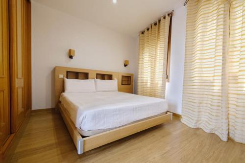 a bedroom with a large white bed in a room at Los Miradores del Arrabal in Toledo