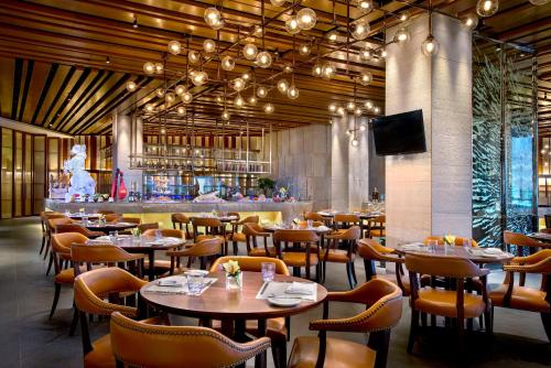a restaurant with tables and chairs and a bar at Kempinski Hotel Changsha in Changsha