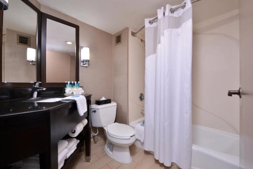 een badkamer met een toilet, een wastafel en een douche bij Holiday Inn Express Burlington, an IHG Hotel in Burlington