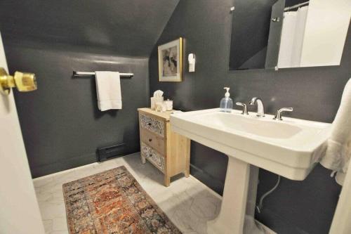uma casa de banho com um lavatório branco e um espelho. em The Hyde Park Suite - 2 Beds em Cincinnati