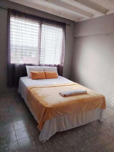 una camera da letto con un letto con due cuscini e una finestra di Fresco apto a 10 min del aeropuerto y la ciudad a Città di Panama