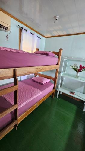 two bunk beds in a room with a green floor at Bastimentos Hill Guest House in Bocas del Toro
