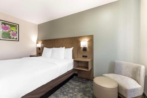 ein Hotelzimmer mit einem Bett und einem Stuhl in der Unterkunft Best Western North Side Inn in Wichita Falls