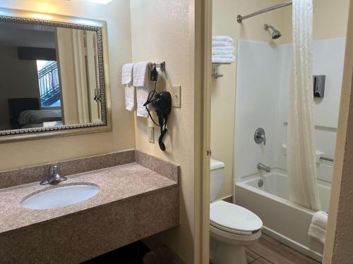 a bathroom with a sink and a toilet and a mirror at Motel 6 Forsyth, GA Tift College in Forsyth