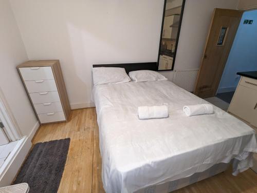 a bedroom with a bed with two towels on it at Stepney Green Self Contained Studio in London