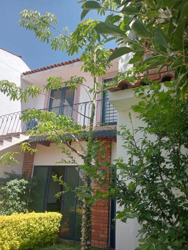 ein weißes Haus mit einem Balkon und Bäumen in der Unterkunft Casa Moreliana in Morelia