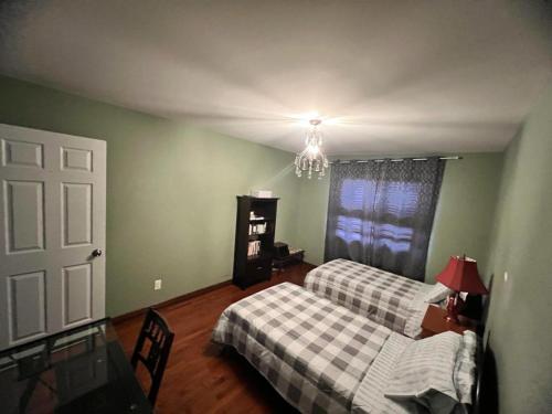 a bedroom with two beds and a chandelier at Hotel/Home in Windsor