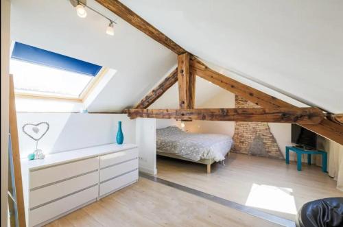 ein Schlafzimmer mit einem Bett im Dachgeschoss in der Unterkunft Jolie maison avec piscine et proche des montagnes in Fontaine