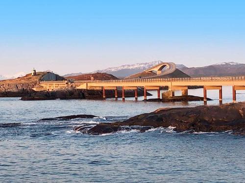 a bridge over a body of water with mountains in the background at 6 person holiday home in AVERØY in Stein