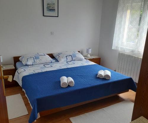 a bedroom with a blue bed with two white slippers at Apartments with a parking space Selce, Crikvenica - 2361 in Selce