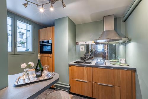 une cuisine avec un évier et une cuisinière four supérieur dans l'établissement Spacieux appartement Paris 17ème - Batignolles, à Paris