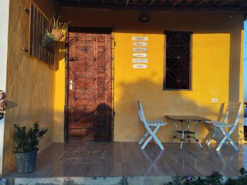 a house with a table and chairs and a door at Colina dos Ventos in Mulungu
