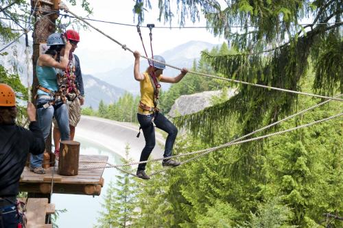a group of people on a zip line in the mountains at Berg-Spa & Hotel Zamangspitze in Sankt Gallenkirch