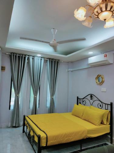 a bedroom with a bed with yellow sheets and a ceiling at Homestay Ummie 