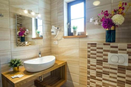 baño con lavabo, espejo y flores en Rooms with a parking space Jezerce, Plitvice - 22116, en Lagos de Plitvice