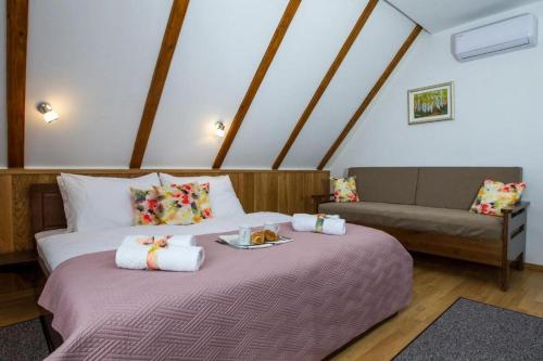 1 dormitorio con 1 cama y 1 sofá en el ático en Rooms with a parking space Jezerce, Plitvice - 22116, en Lagos de Plitvice