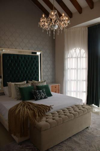 a bedroom with a large bed with a chandelier at Luxury Mansion Sant Serrant Cerca Aeropuerto Medellín Guatapé in Marinilla