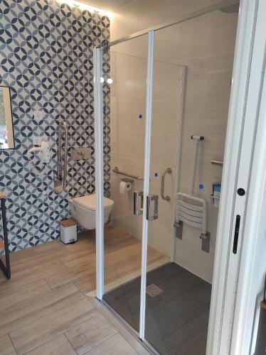 a bathroom with a toilet and a glass shower at Kaixo Family in Zarautz