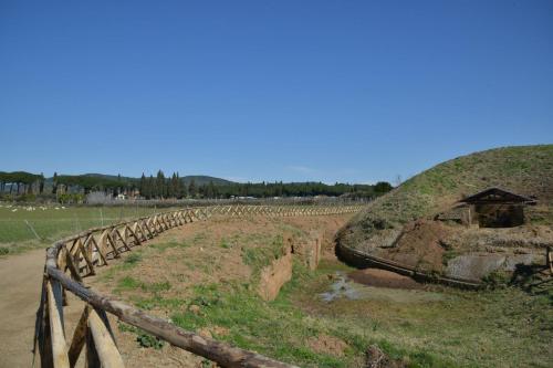 a field with a hill with a fence next to it at Agriturismo Casale Di Gricciano in Cerveteri