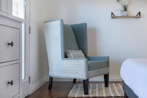 a blue chair sitting in a bedroom next to a bed at 3 Bedroom House - Fire Pit Table BBQ - 10 Guests in La Mesa