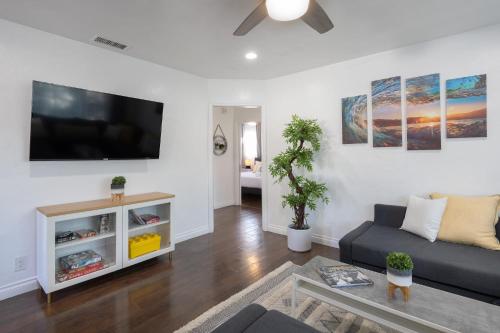 a living room with a couch and a flat screen tv at 3 Bedroom House - Fire Pit Table BBQ - 10 Guests in La Mesa