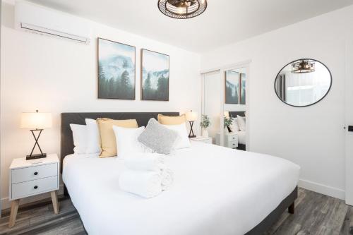 a white bedroom with a large white bed at 2 Bedroom House - Fire Pit Table BBQ - Downtown in San Diego