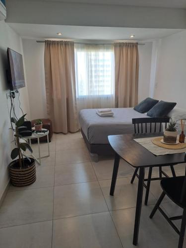 een hotelkamer met een bed en een tafel en een eetkamer bij Cómodo monoambiente en Salta 246 in Neuquén