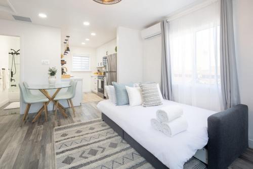 a white bedroom with a bed and a table at 3 Bed House with Fire Pit Table and BBQ - Downtown in San Diego