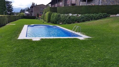 una pequeña piscina en un patio de césped en Apartment Bolvir Fantásticas Vistas, en Bolvir