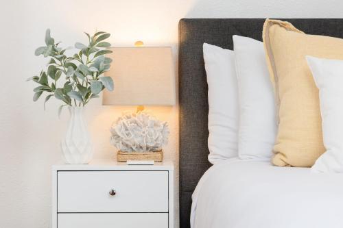 a vase of flowers on a night stand next to a bed at 2 Bedroom - Ocean View Hot Tub Parking - 8 Guest in San Diego