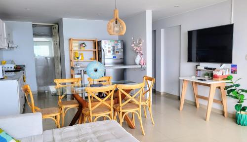 una sala da pranzo con tavolo in vetro e sedie di Apartamento Playa Señoritas a Punta Hermosa