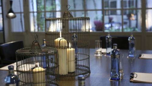 three candles in bird cages on a table at Ofelias Hotel 4Sup in Barcelona