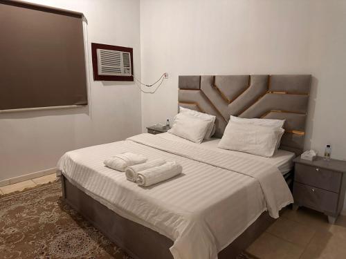 a bedroom with a large bed with towels on it at شقق ارجان نجد المفروشه in Al Nairyah