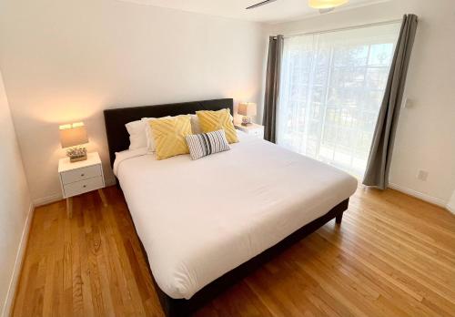 Schlafzimmer mit einem Bett mit weißer Bettwäsche und gelben Kissen in der Unterkunft Hidden Gem with Hot Tub and Parking - 4 Guests in San Diego