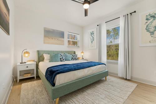 Un dormitorio con una cama con almohadas azules y una ventana en Somerset by the Sea - 4 BR, Sleeps 12, Golf Cart, Bikes, Private Pool and close to the BEACH!, en Seagrove Beach