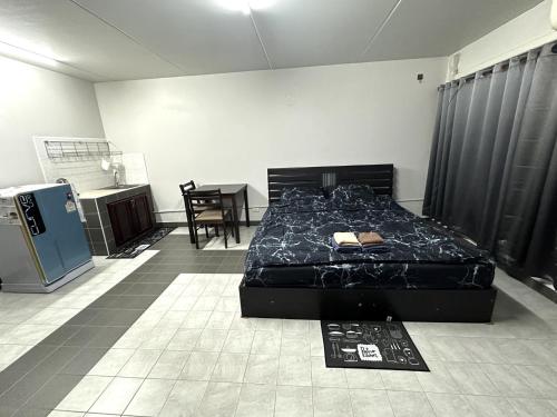 a bedroom with a bed and a table in it at Muangthong p2 in Ban Song Hong