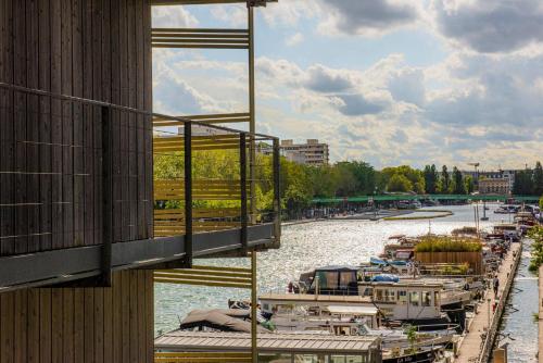 a group of boats are docked on a river at Holiday Inn Express Paris-Canal De La Villette by IHG in Paris