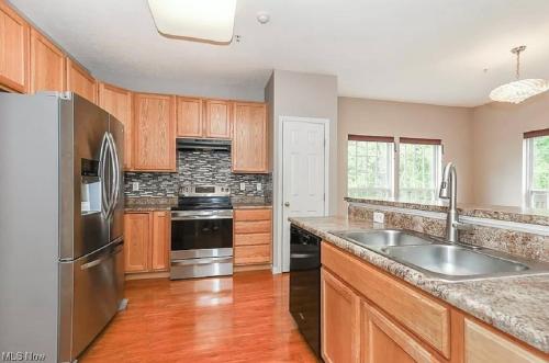 a kitchen with wooden cabinets and stainless steel appliances at Condo Townhome - Cleveland Lake Area 