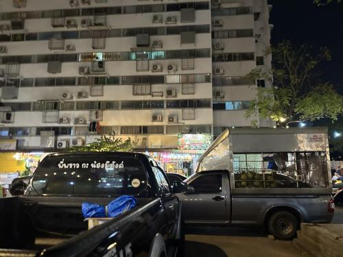 a truck parked in front of a tall building at Muangthong p2 in Ban Song Hong
