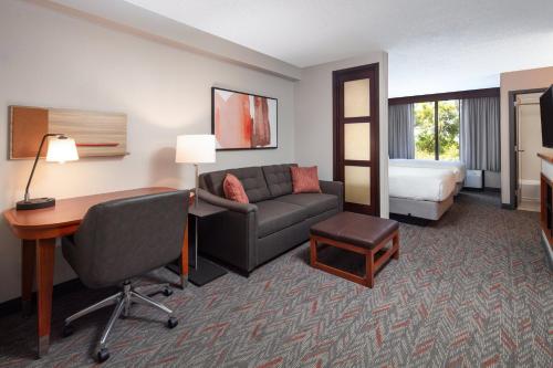 a hotel room with a couch and a desk and a bed at Candlewood Suites - Birmingham - Inverness, an IHG Hotel in Birmingham