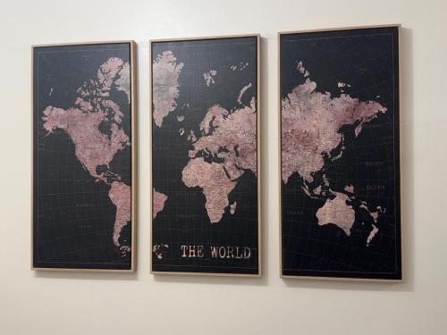 three framed maps of the world on a wall at Tayy’s Inn in Birmingham