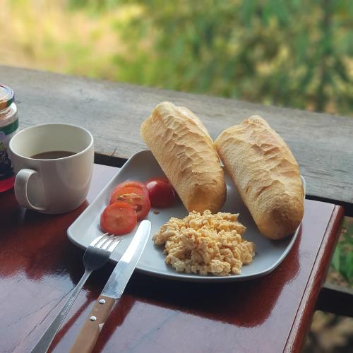 a plate of food with bread and a cup of coffee at Banlung Mountain View Treks & Tours in Banlung
